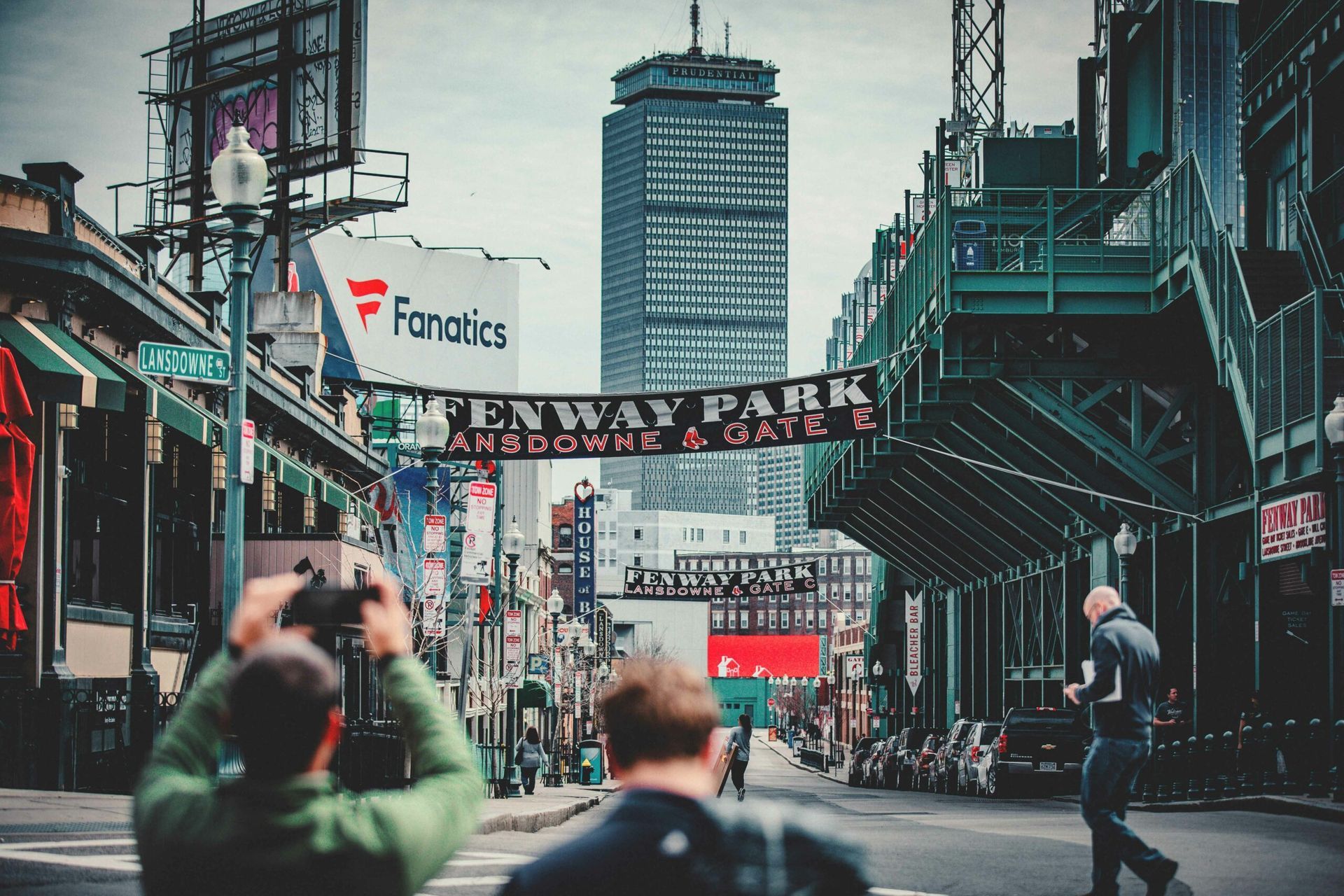 People in front of Fenway Park in Boston, with a large skyscraper in the distance.