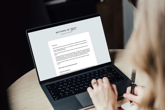 Person typing on a laptop showing a document on screen