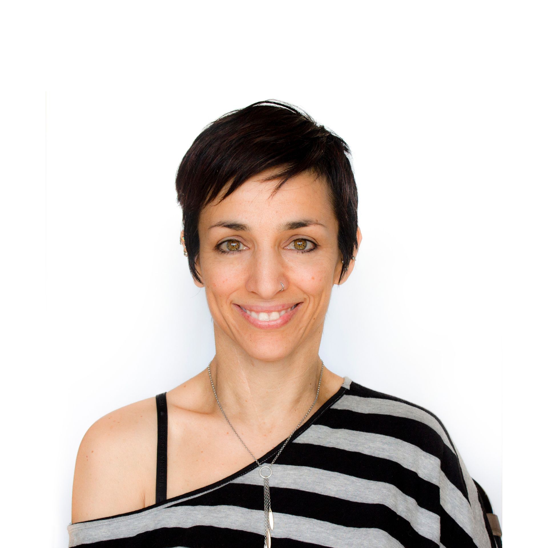 Smiling person with short dark hair wearing a black-and-white striped top against a white background