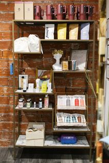 Shelf of assorted packaged goods and bottles in a brick-walled store display