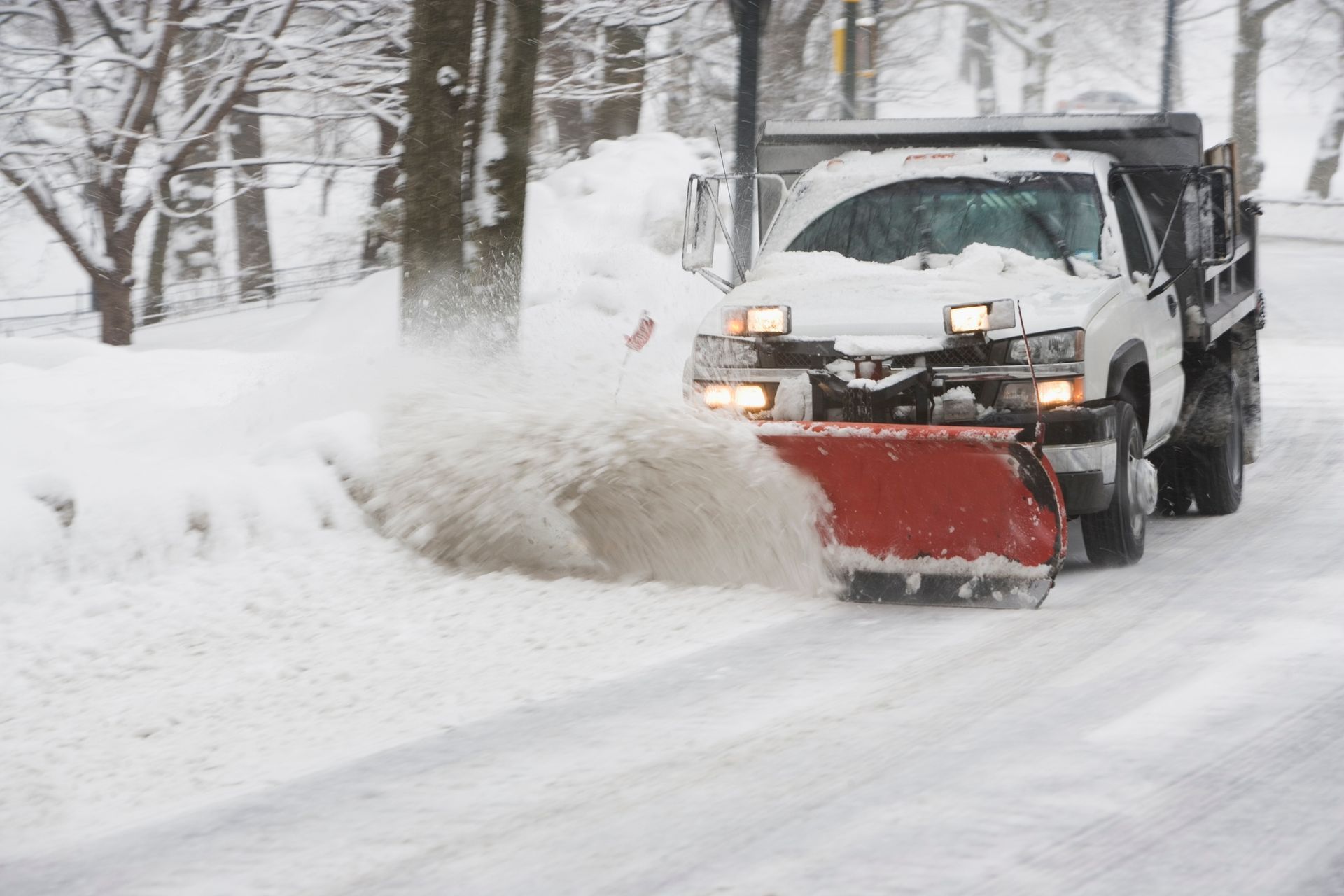 Snowplow clearing snow from a street on a snowy day. Snowplow clearing snow from a street on a snowy day.