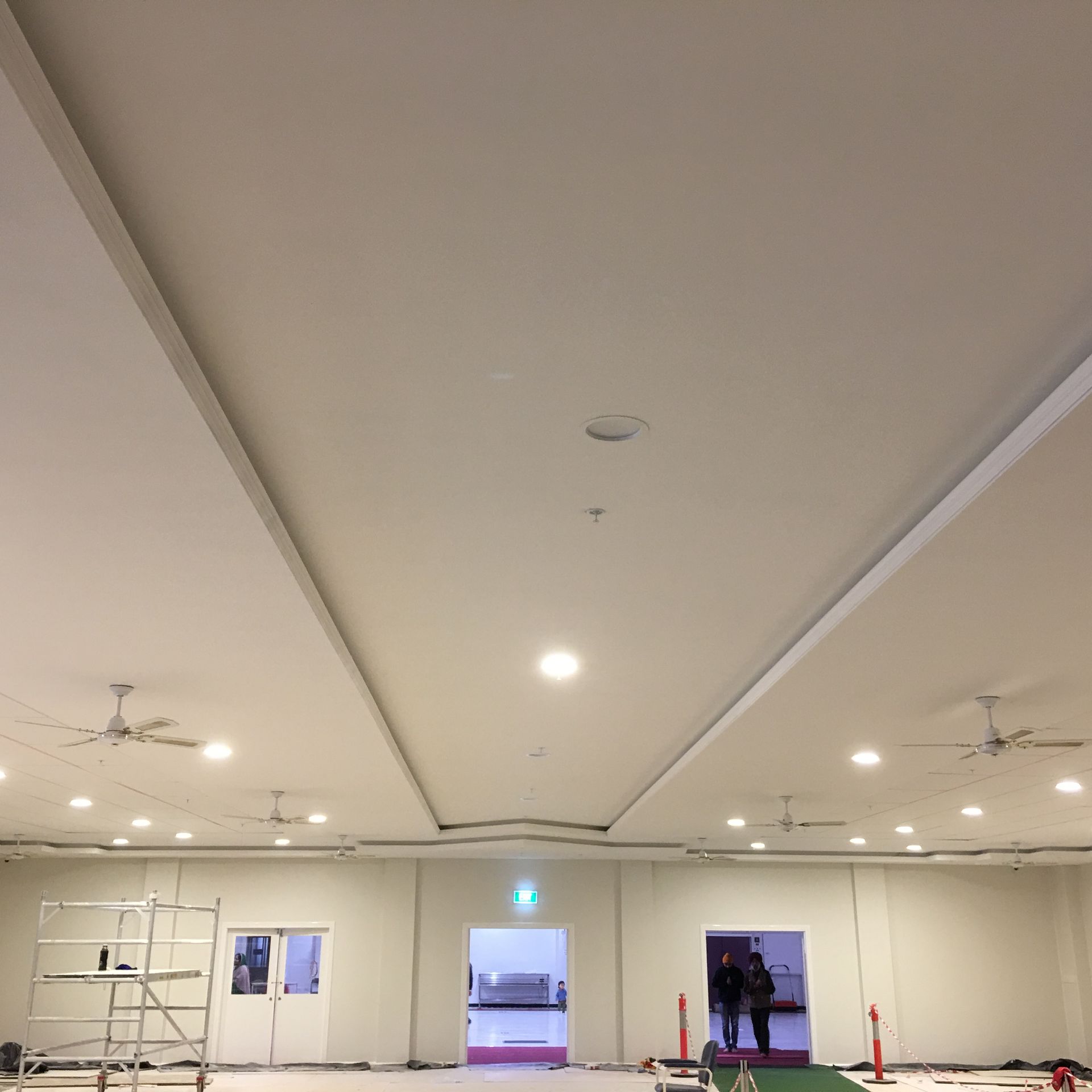 A large room with white walls and ceiling fans