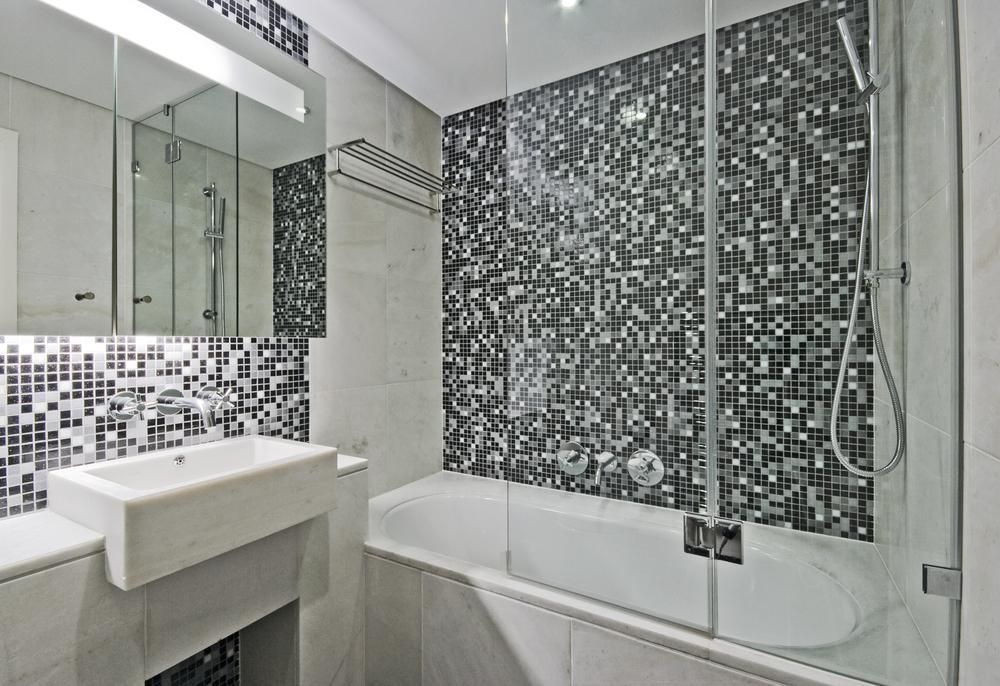 A bathroom with a bathtub , sink , mirror and shower.