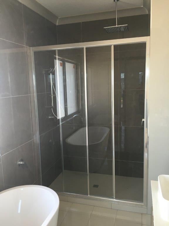 A Bathroom With A Bathtub , Shower , And Sliding Glass Doors — MRS–Mirrors, Robes & Shower Screens In Yarrawonga, NT