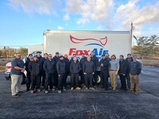 Group of Fox Air employees standing in front of a company truck outdoors.
