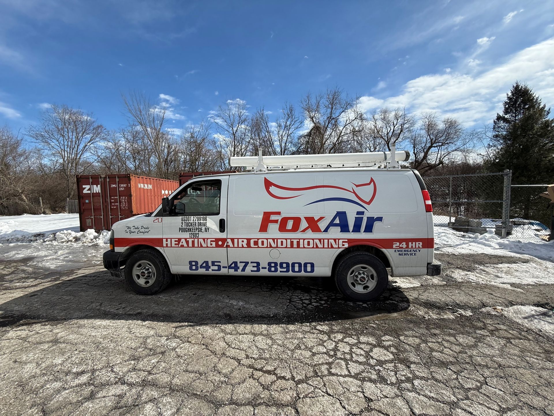 FoxAir service van parked on snowy pavement under a blue sky