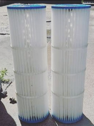 Two cylindrical white pleated pool filters with blue ends.