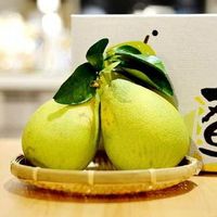 桌上的竹籃裡放著兩個柚子。