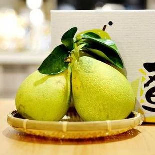 桌上的竹籃裡放著兩個柚子。