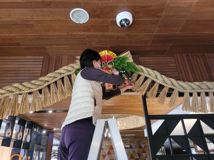 一名婦女站在梯子上,用鮮花裝飾天花板。