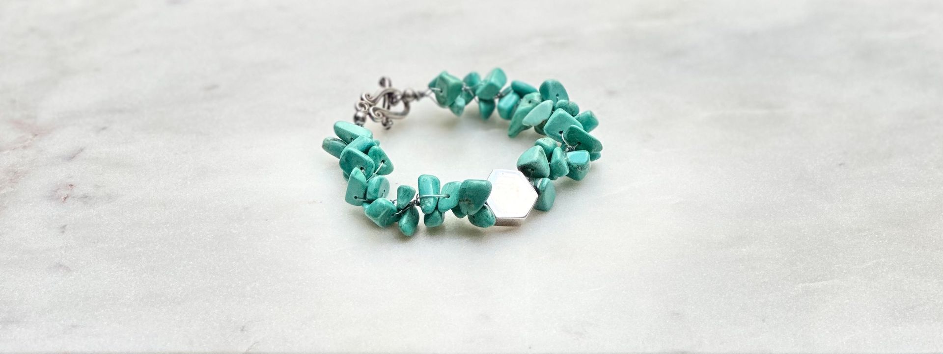 Turquoise chip bracelet on a white surface.