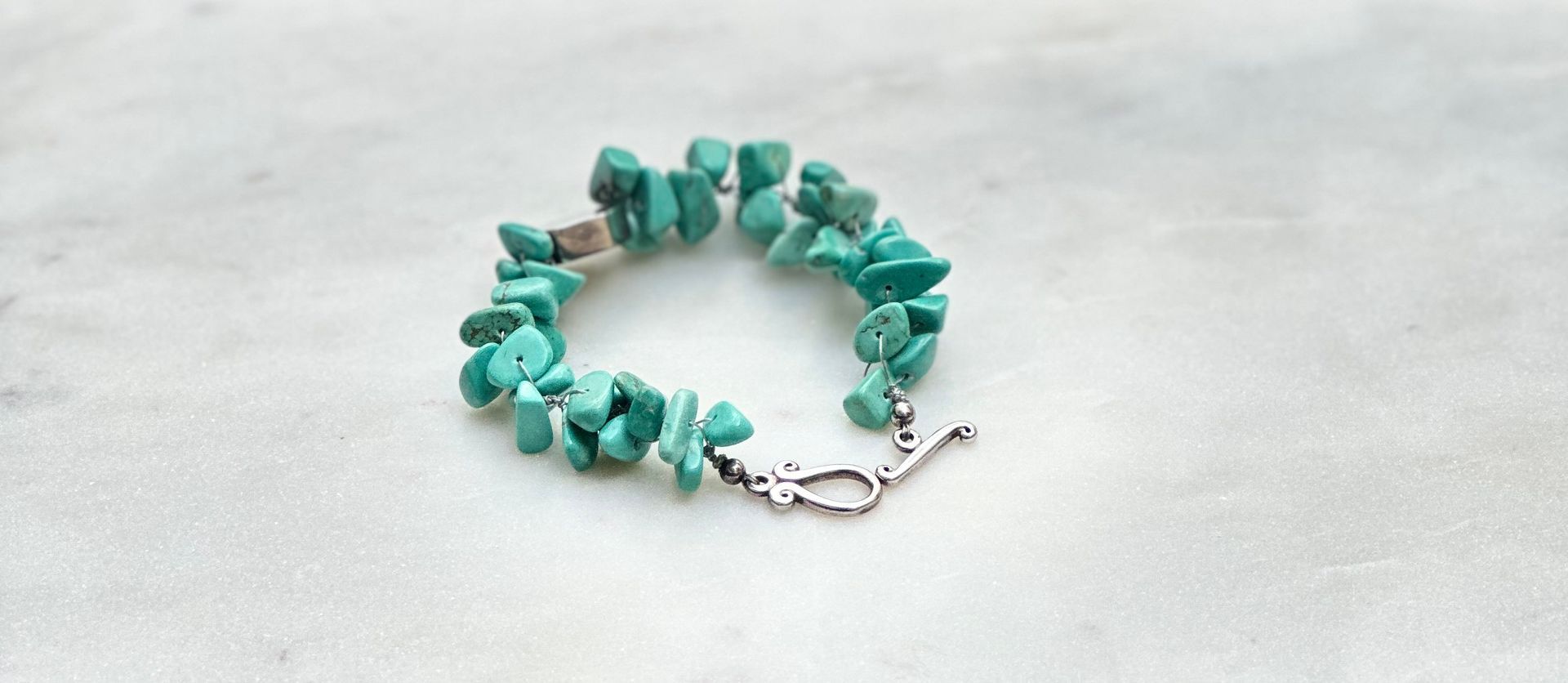 Turquoise chip bracelet on a white surface.