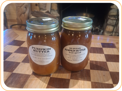 Two jars of pumpkin butter on a wooden table. One says 
