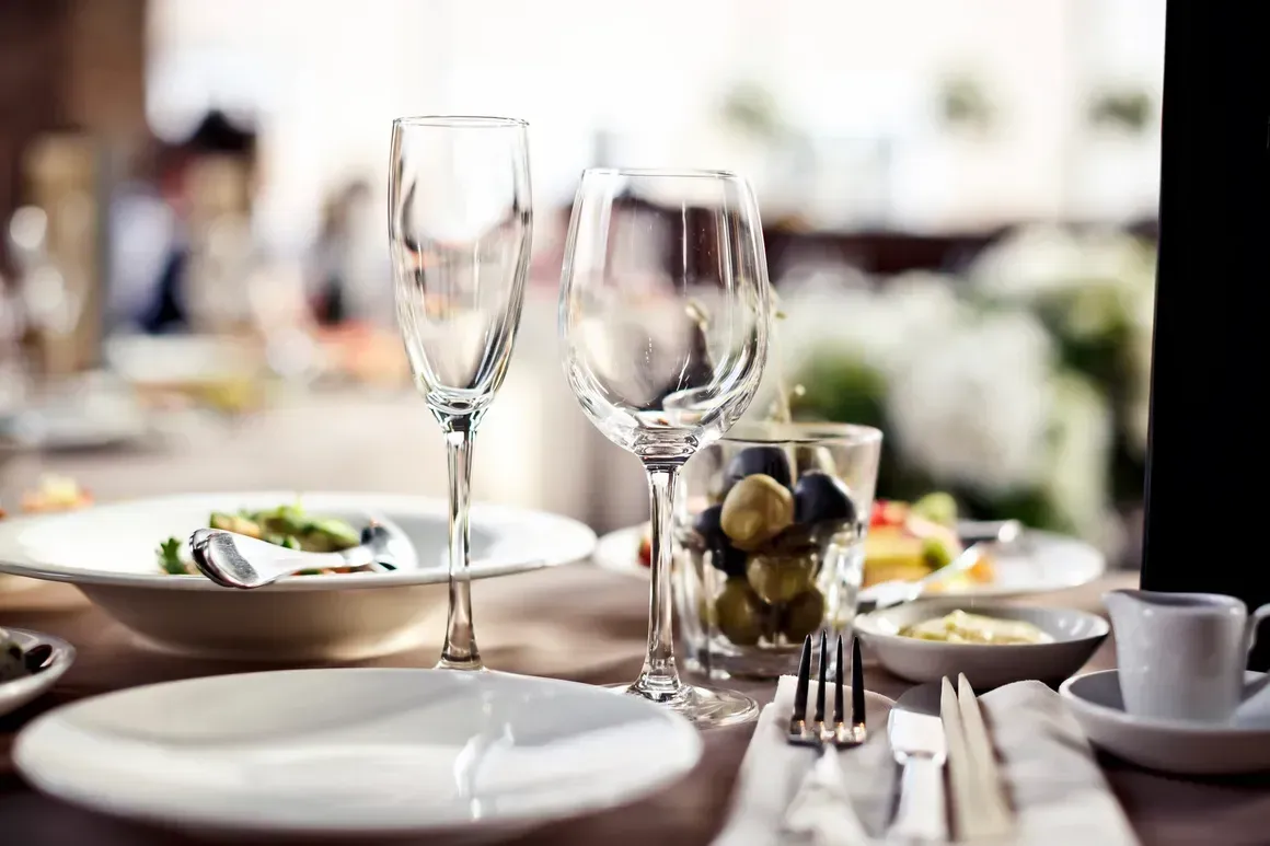 A table set for a meal with plates , wine glasses , and utensils.