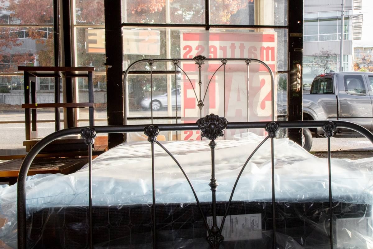 Metal bed frame in front of a window with a snowy street outside