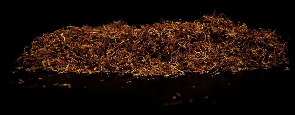 Un mucchio di foglie di tabacco su uno sfondo nero