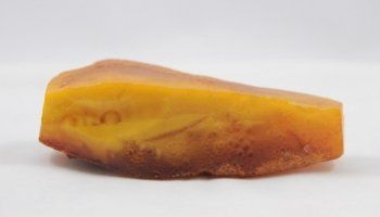Un pezzo di ambra è appoggiato su una superficie bianca.