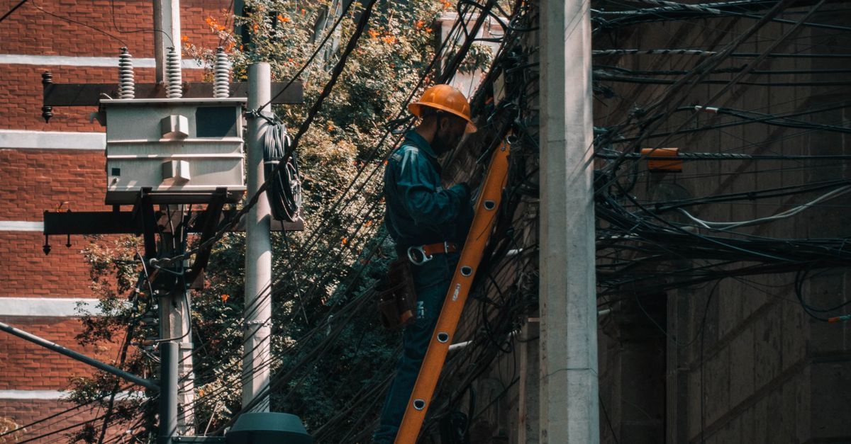 Electrician reviewing a customer service request beside a service van