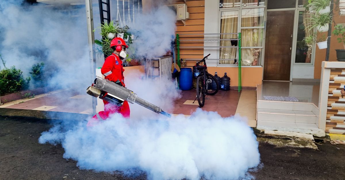 Pest control technician speaking with a homeowner outside a home