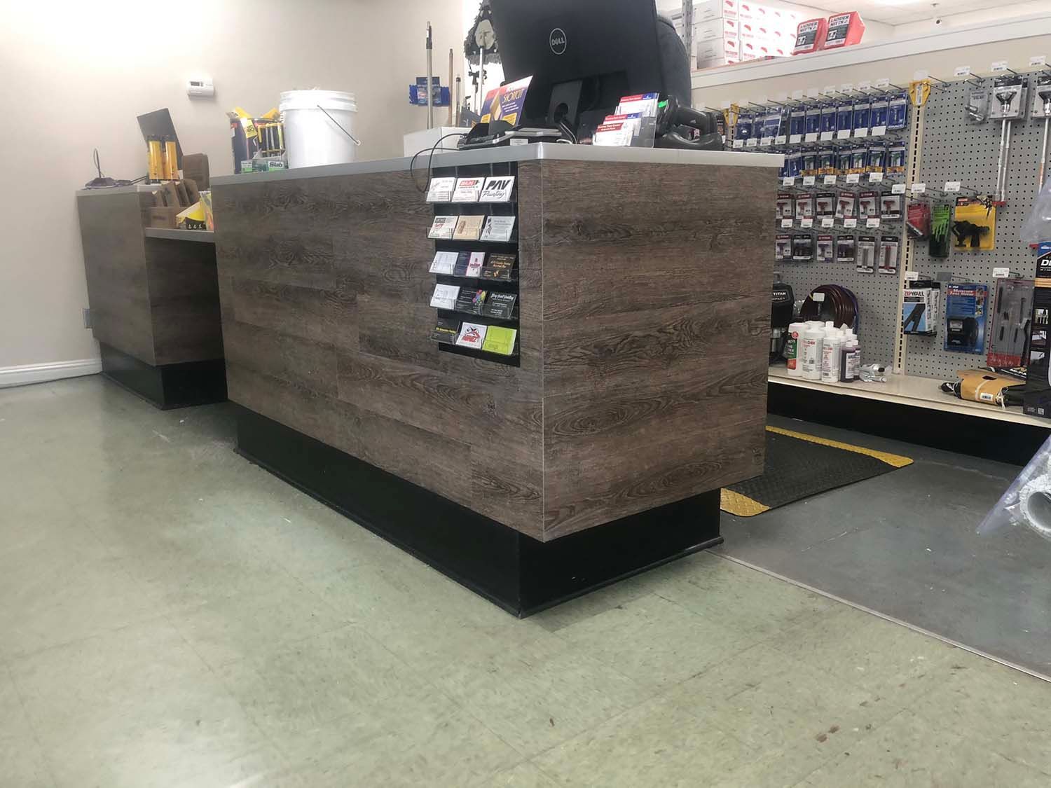 Hardware store counter with brown textured wrap, display tags, and shelves of supplies in the background