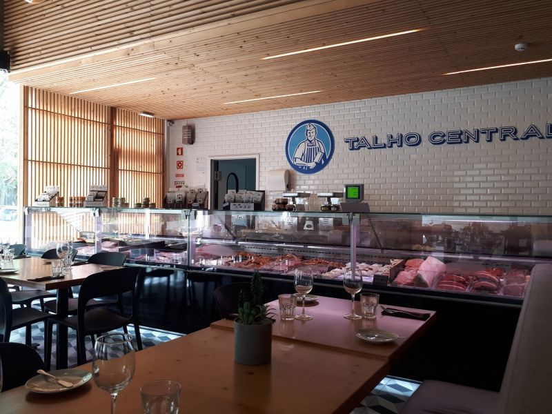 Restaurante de frutos do mar estilo buffet com balcões de vidro e iluminação de teto de madeira.