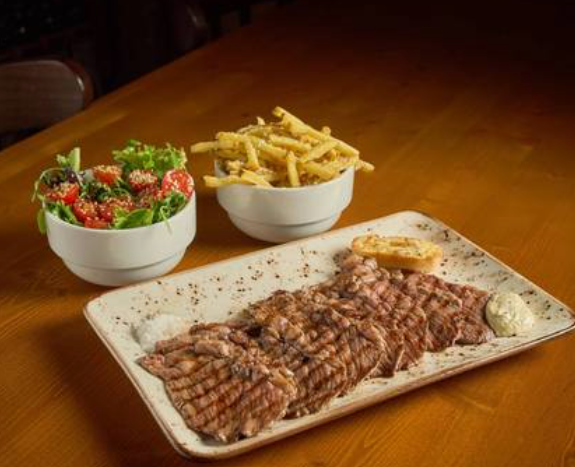 Sanduíche de bife com batatas fritas em uma bandeja de madeira