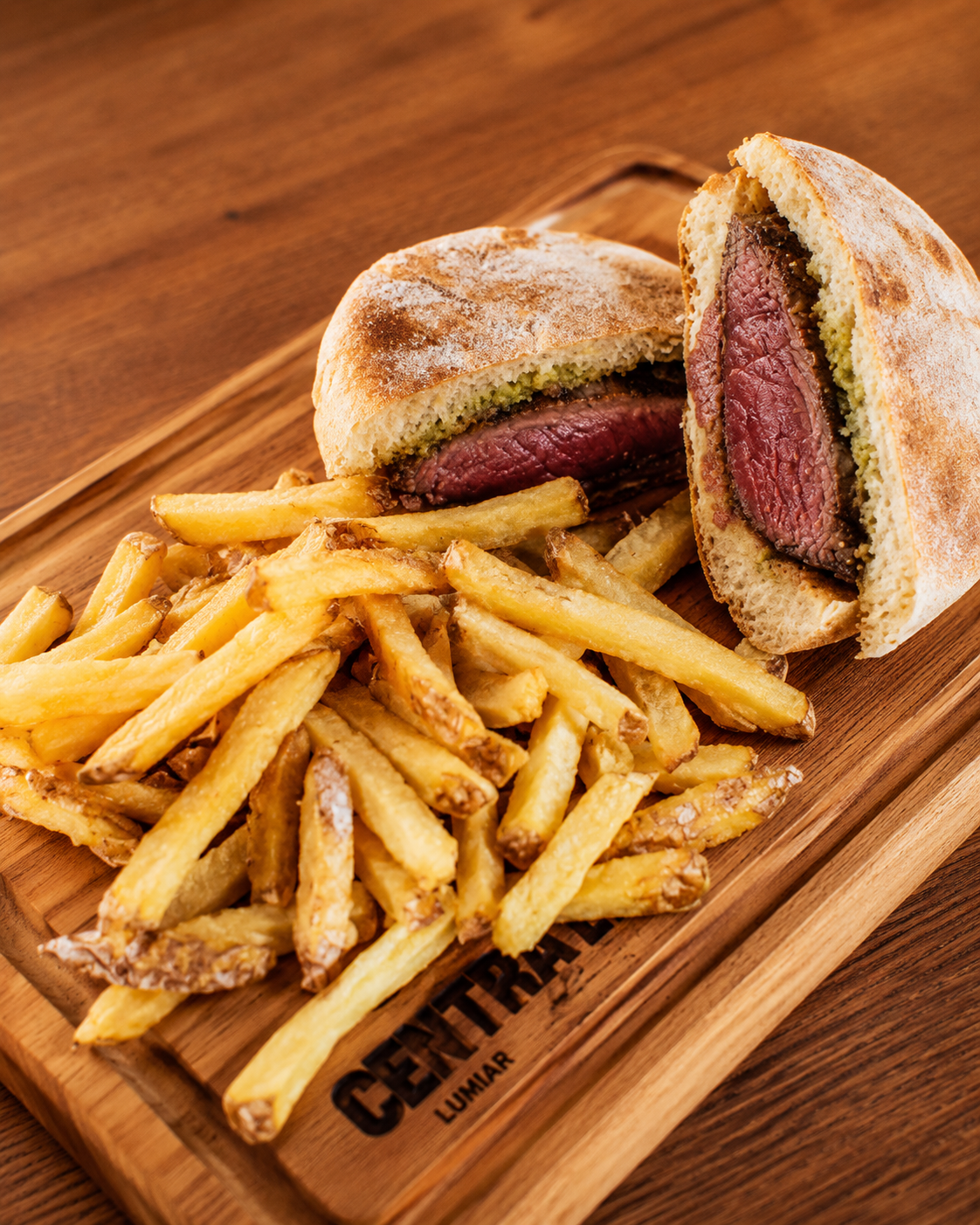 Sanduíche de bife com batatas fritas em uma bandeja de madeira