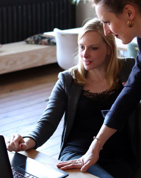 Two women are looking at a laptop computer together