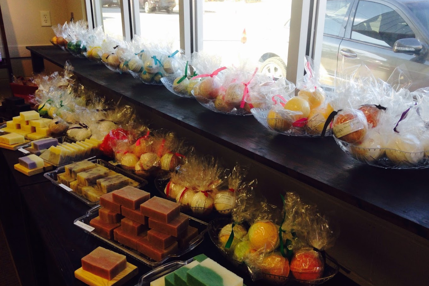 A shelf filled with a variety of fruits and vegetables wrapped in plastic.