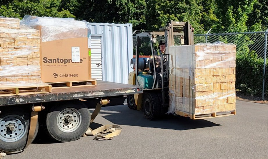 A Forklift is carrying a pallet of wooden stakes