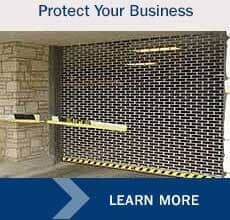 Rolling security gate, protecting a business entrance. Brick pattern, yellow caution strip, and 