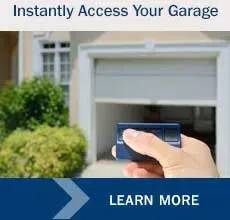Hand holding blue garage door opener, opening garage door.