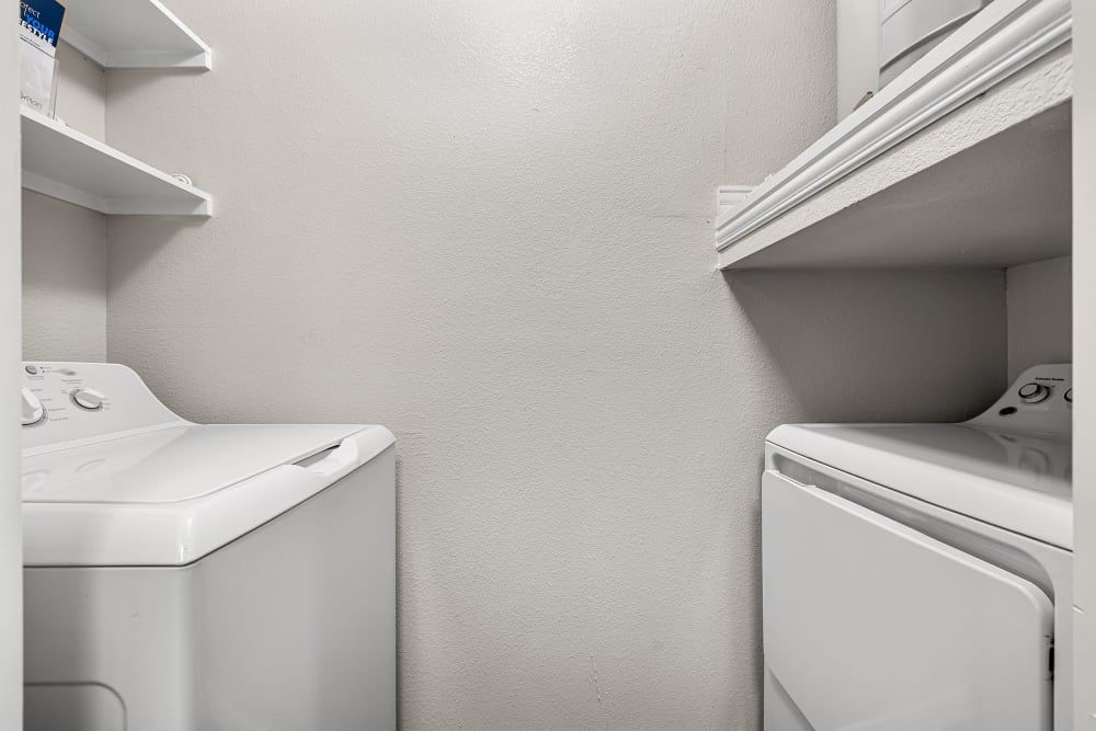 A laundry room with a washer and dryer in it at Marquis at Silver Oaks in Grapevine, TX.