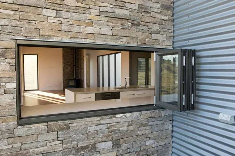 A Large Window In A Stone Wall With A View Of A Kitchen — Nambucca Glass in Nambucca Heads, NSW