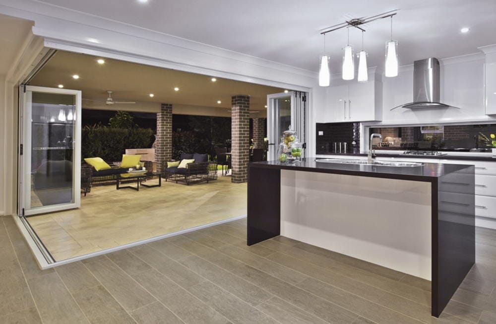 A Kitchen With A Large Island And Sliding Glass Doors Leading To A Patio — Nambucca Glass in Nambucca Heads, NSW