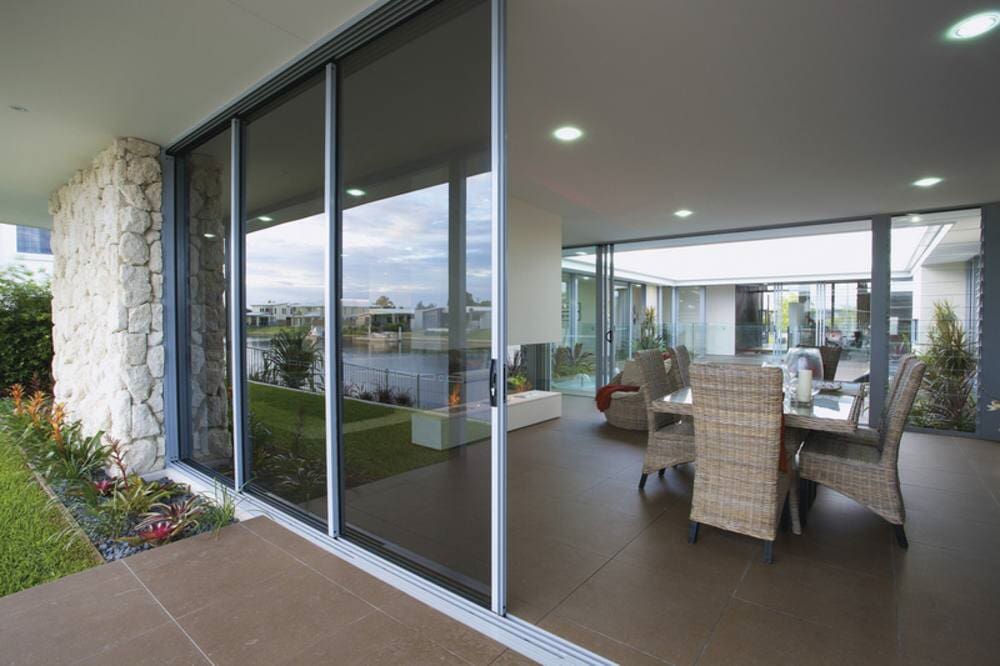 A Living Room With A Table And Chairs And A Sliding Glass Door — Nambucca Glass in Nambucca Heads, NSW