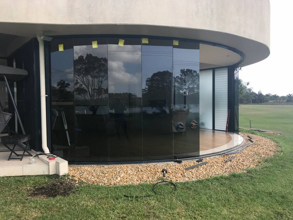 A Building With Sliding Glass Doors Is Being Built In A Grassy Area — Nambucca Glass in Macksville, NSW