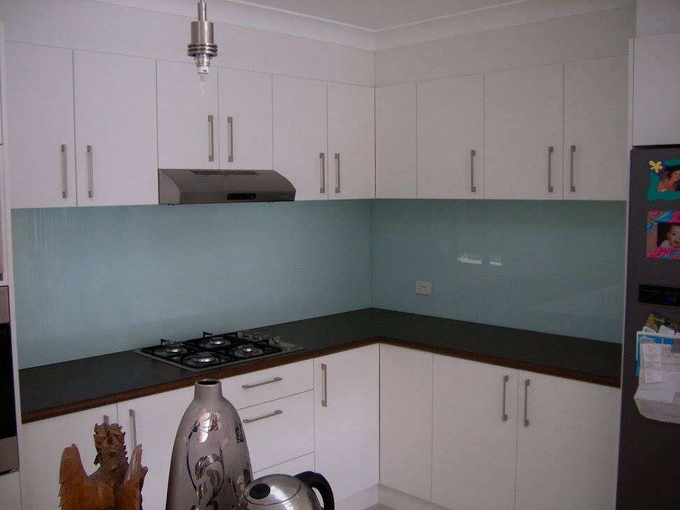 A Kitchen With White Cabinets And A Stove Top Oven In The Transparent Splashback — Nambucca Glass in Nambucca Heads, NSW