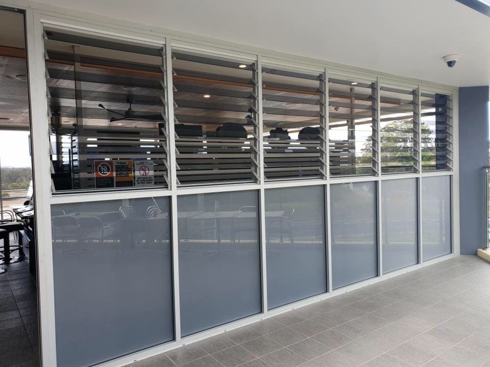 A Building With A Lot Of Windows And A Balcony — Nambucca Glass in Nambucca Heads, NSW