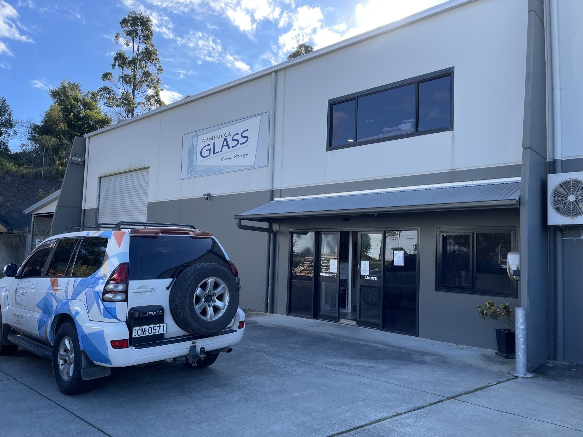 A White Suv Is Parked In Front Of Nambucca Glass Factory — Nambucca Glass in Nambucca Heads, NSW