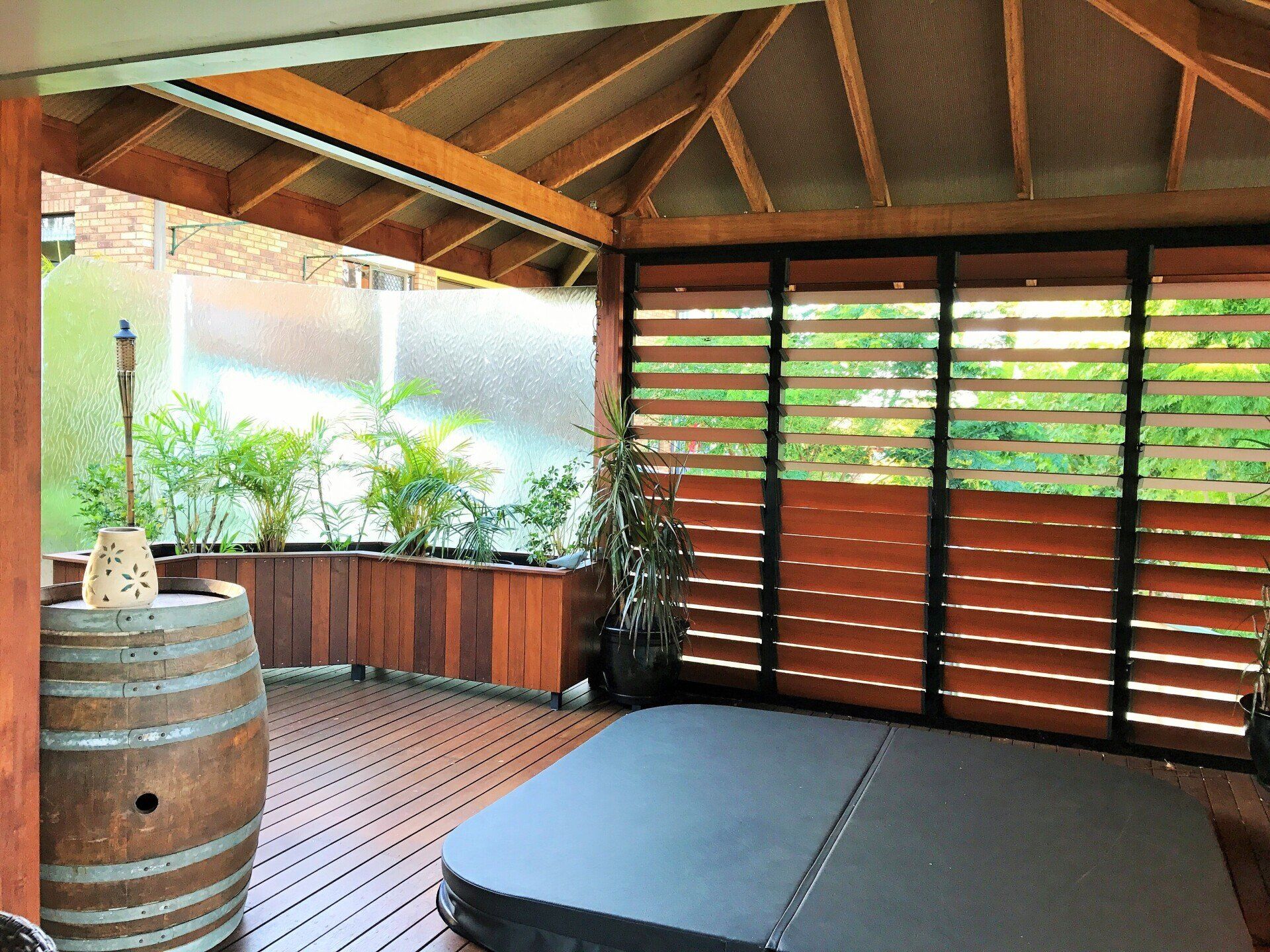 A Hot Tub Is Sitting On A Wooden Deck Under A Gazebo — Nambucca Glass in Nambucca Heads, NSW