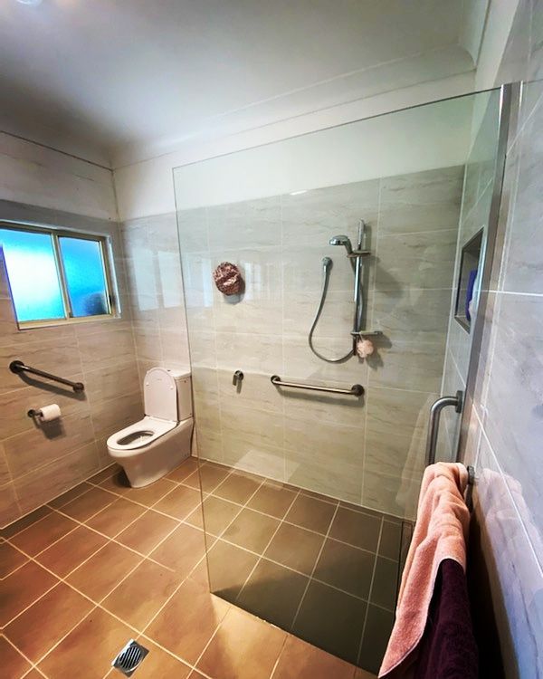 A Bathroom With A Toilet And A Walk In Shower — Nambucca Glass in Nambucca Heads, NSW