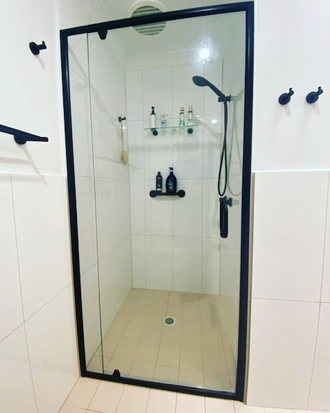 A Shower With A Glass Door And A Black Frame — Nambucca Glass in Nambucca Heads, NSW