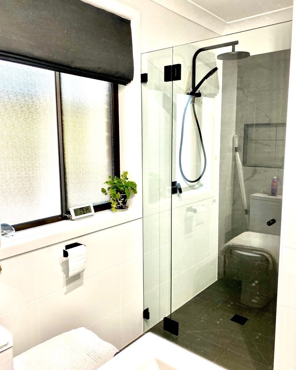 A Bathroom With A Toilet, Shower, And Window — Nambucca Glass in Nambucca Heads, NSW