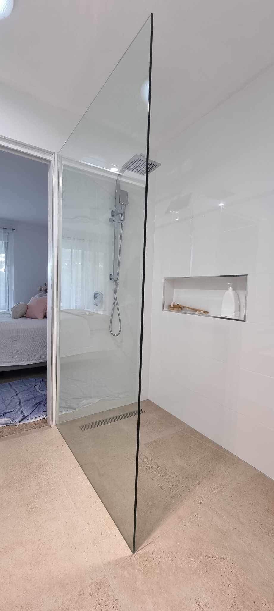A Bathroom With A Walk In Shower And A Bedroom In The Background — Nambucca Glass in Nambucca Heads, NSW