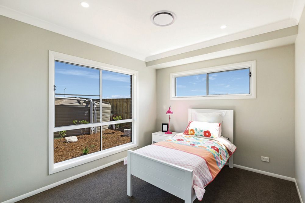 A Bedroom With A Single Bed And A Large Window — Nambucca Glass in Nambucca Heads, NSW