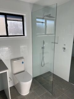 Modern Bathroom with Toilet, Glass Shower, and Floor Tiles — Nambucca Glass in Nambucca Heads, NSW