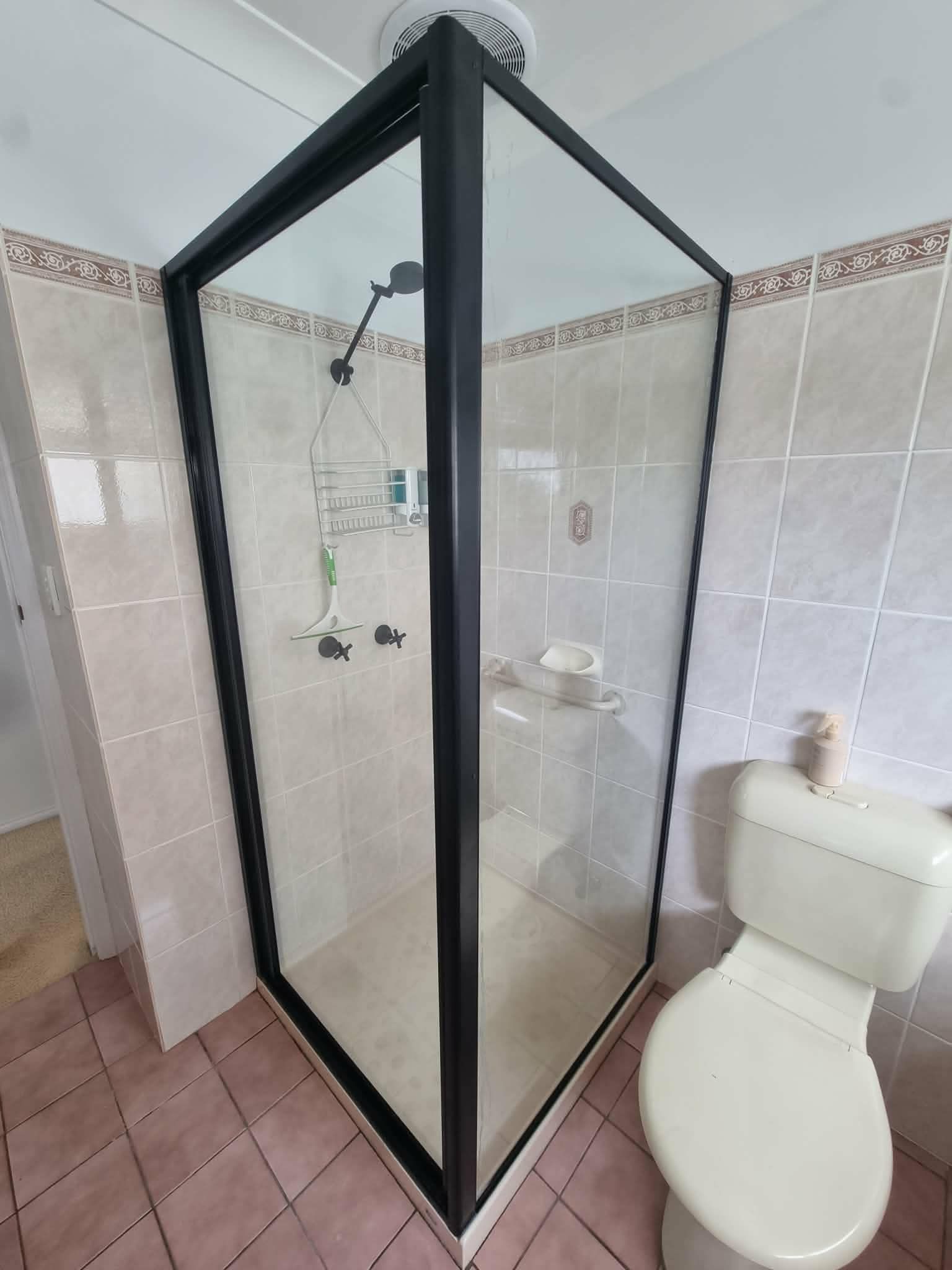 Tiled Bathroom with A Glass Shower Enclosure and A Toilet — Nambucca Glass in Nambucca Heads, NSW