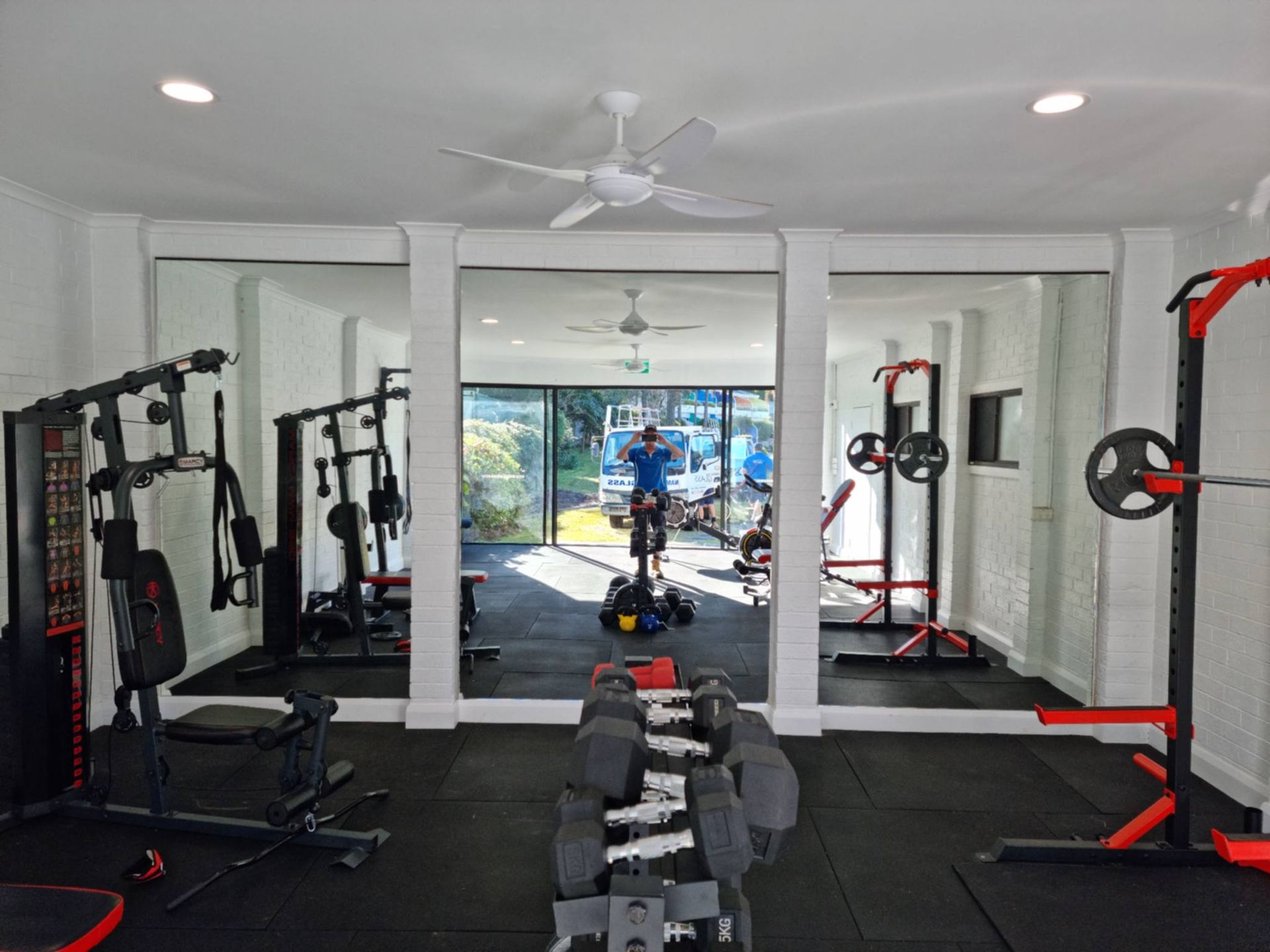 Home Gym With Weight Machines, Bench, Dumbbells, and Mirrored Walls — Nambucca Glass in Nambucca Heads, NSW