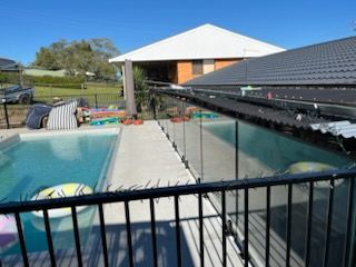 Backyard Pool Beside a Covered Patio and Glass Fence — Nambucca Glass in Nambucca Heads, NSW